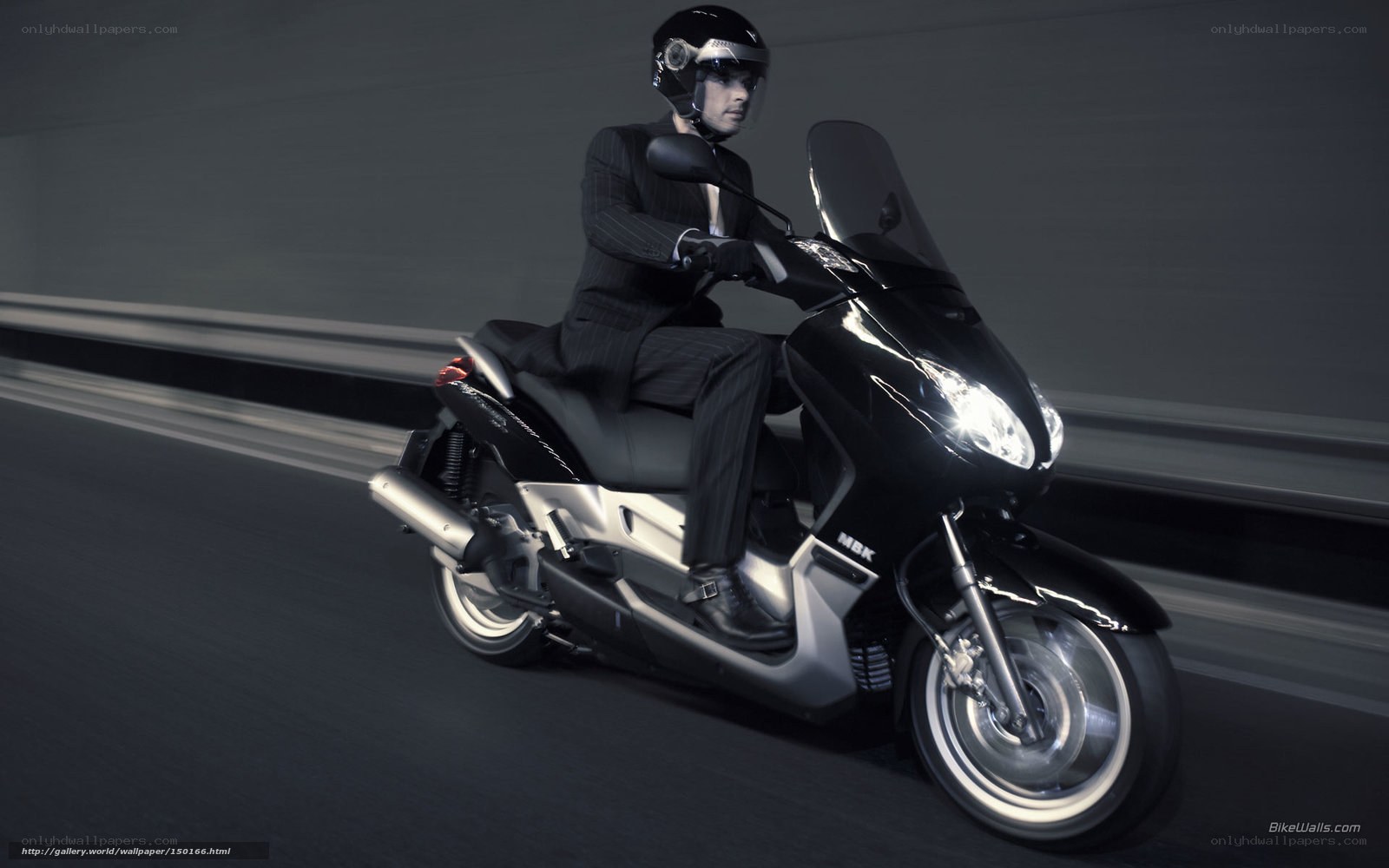 man in suit riding scooter