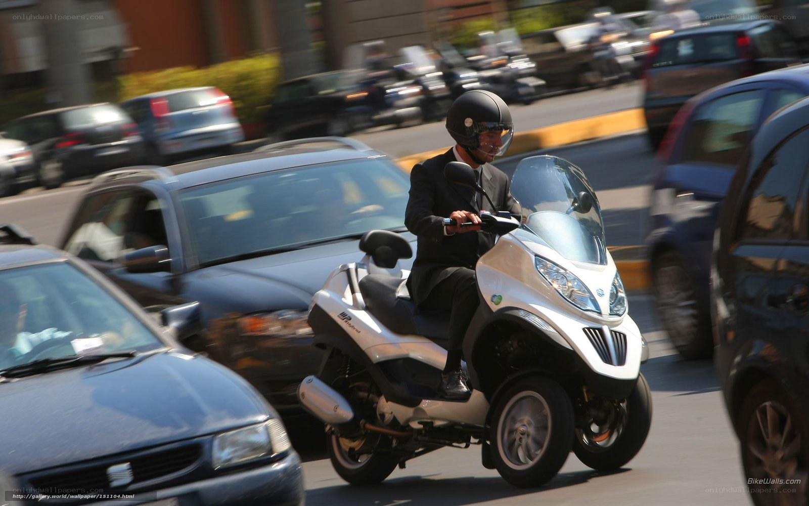 Man in suit riding scooter