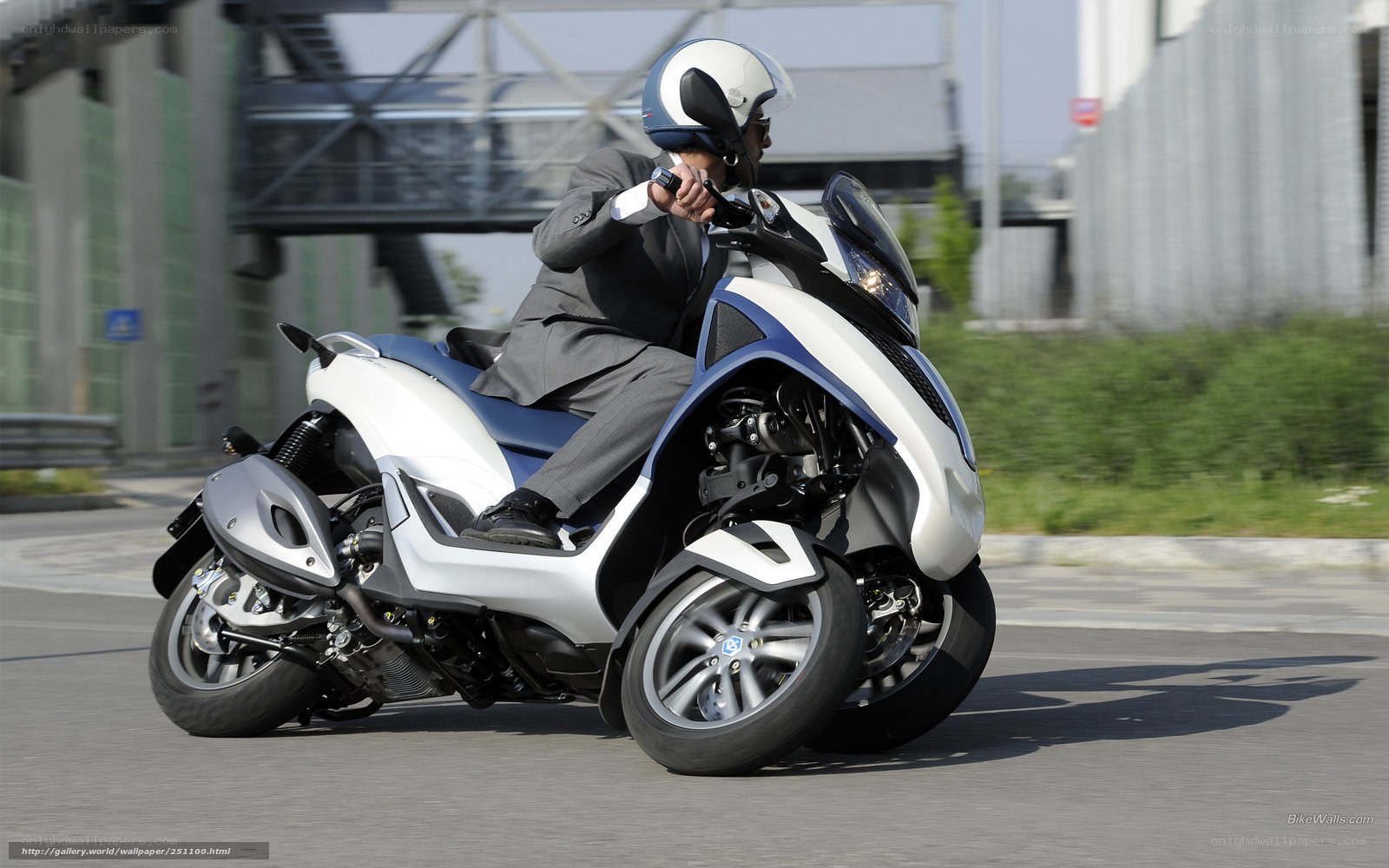 Man in suit riding scooter