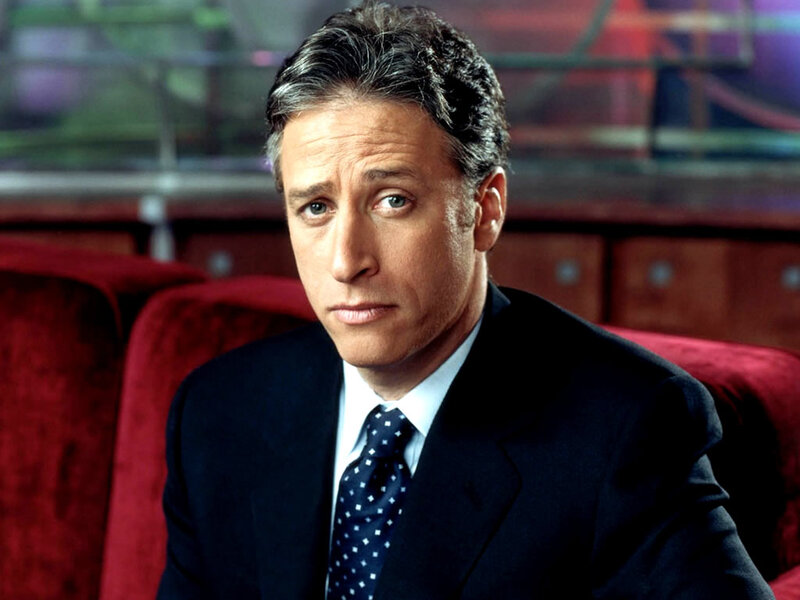 Man in Suit Sitting — Black, Serious, Photograph, Red Couch