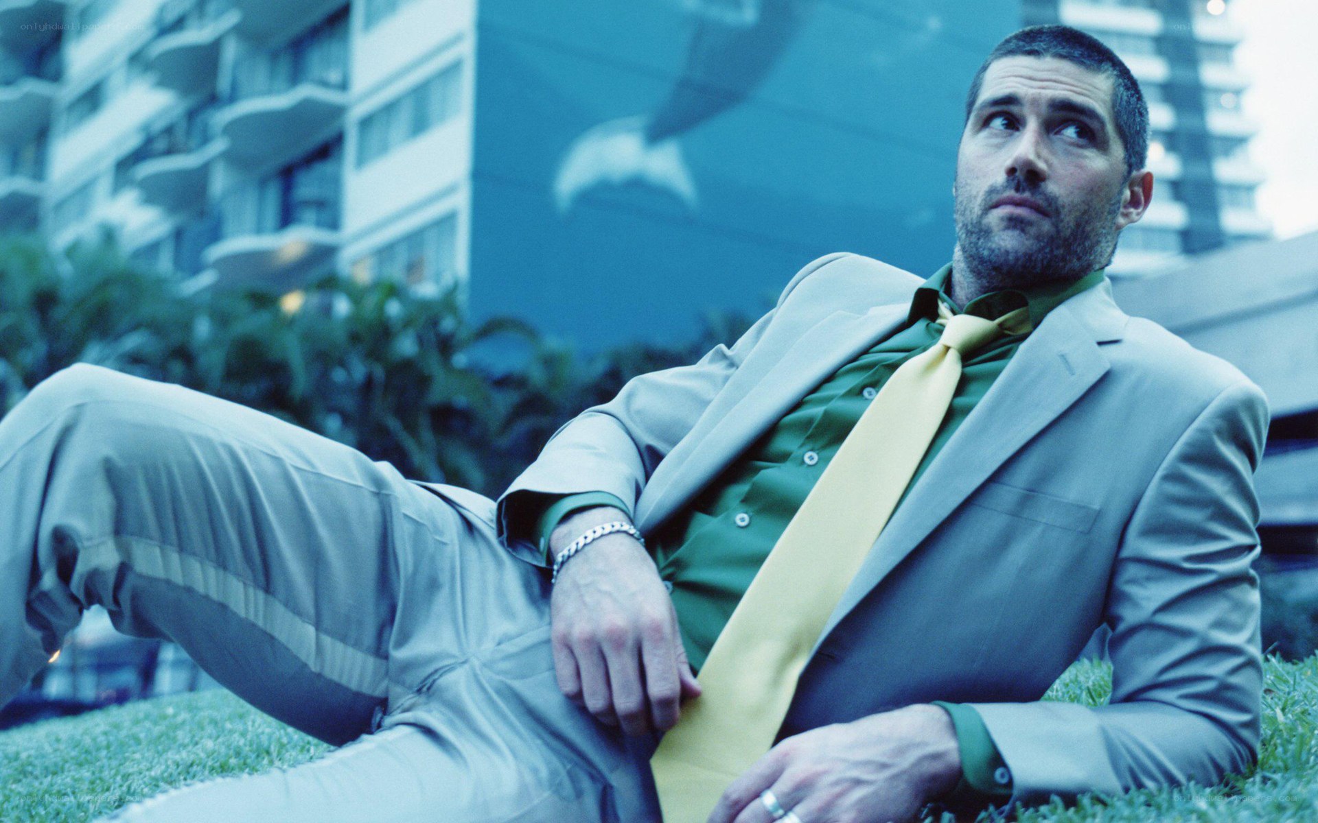 man in suit sitting on grass