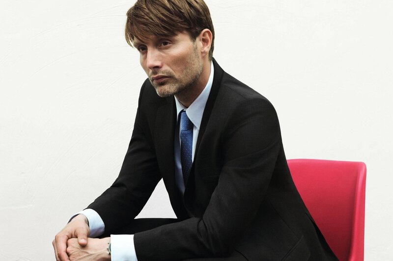 man in suit sitting on red chair