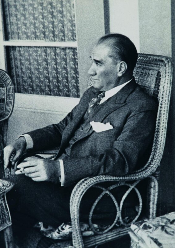 Man in suit sitting on wicker chair