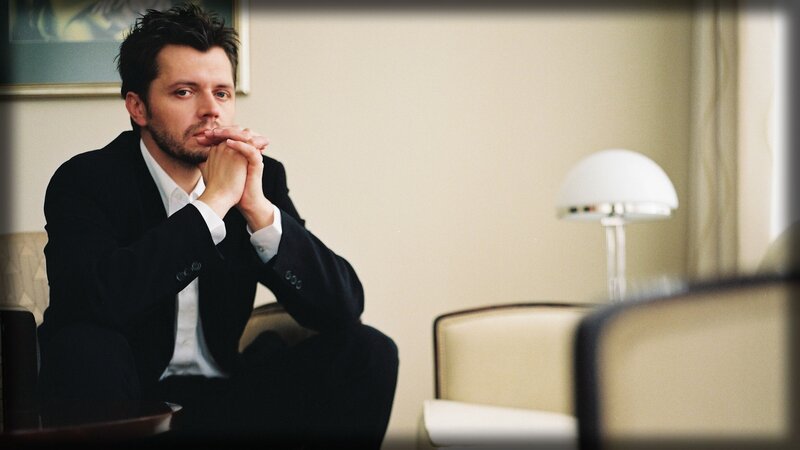 man in suit sitting thoughtfully