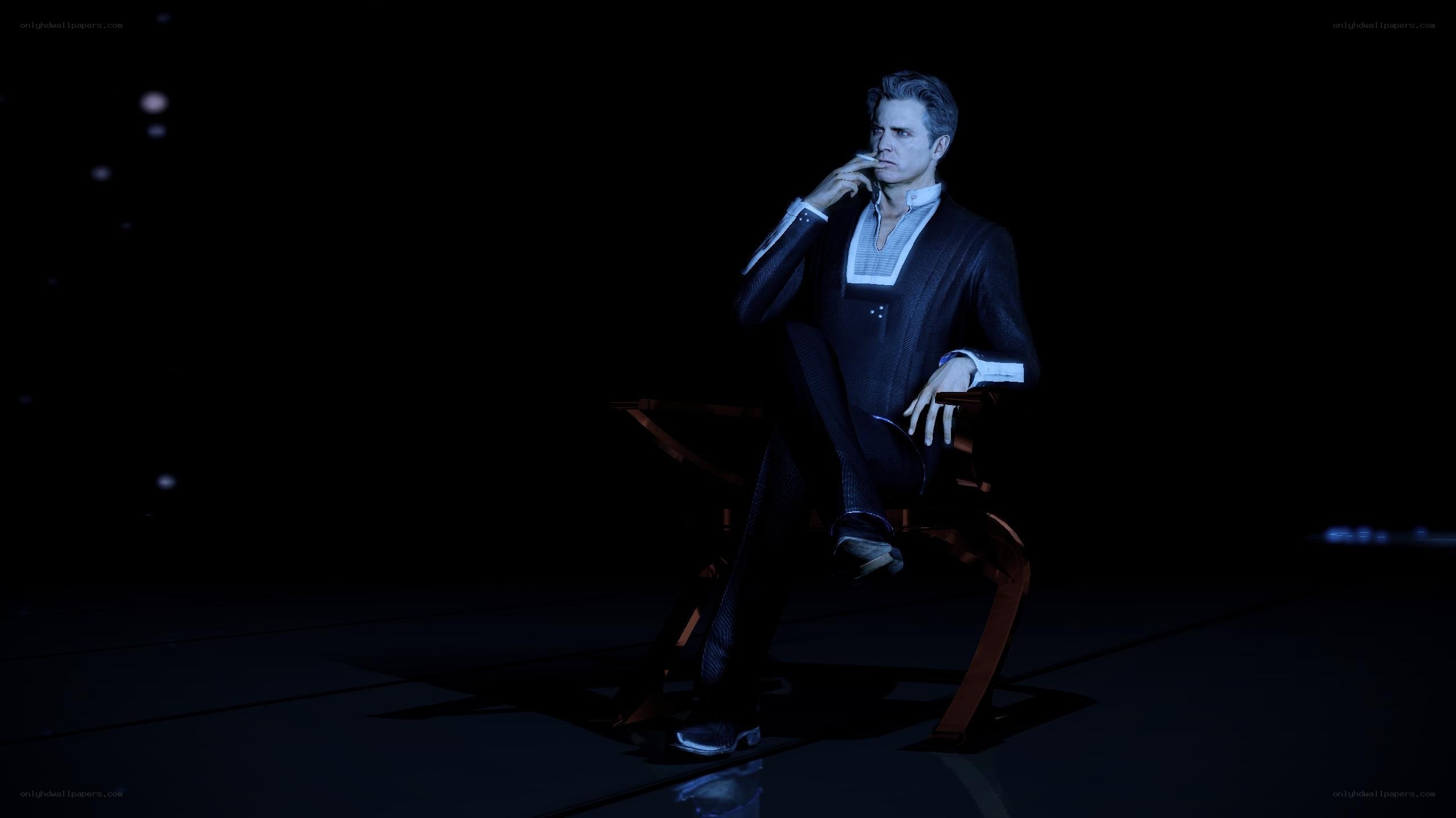 man in suit sitting with cigarette