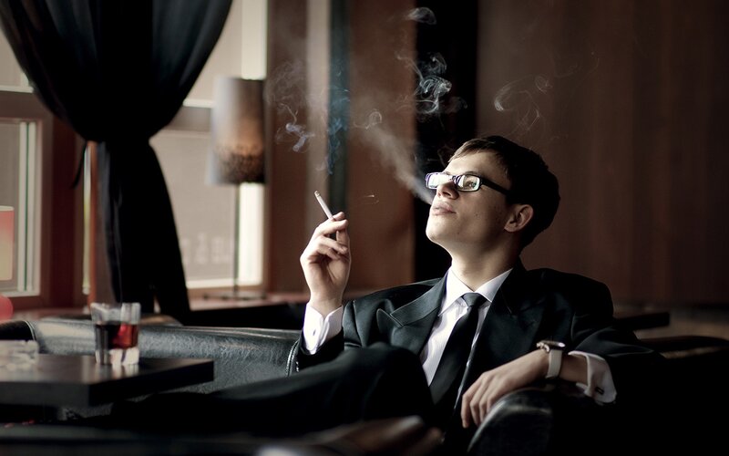 man in suit smoking cigarette