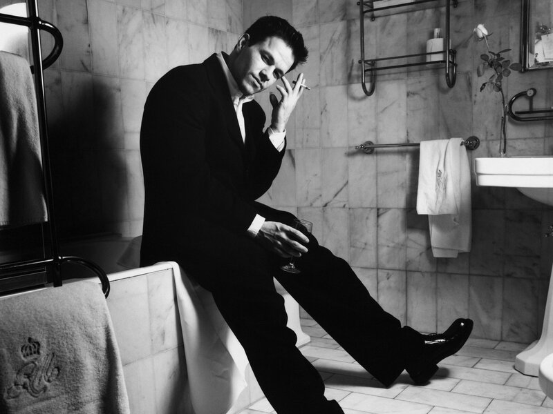 Man in suit smoking in bathroom