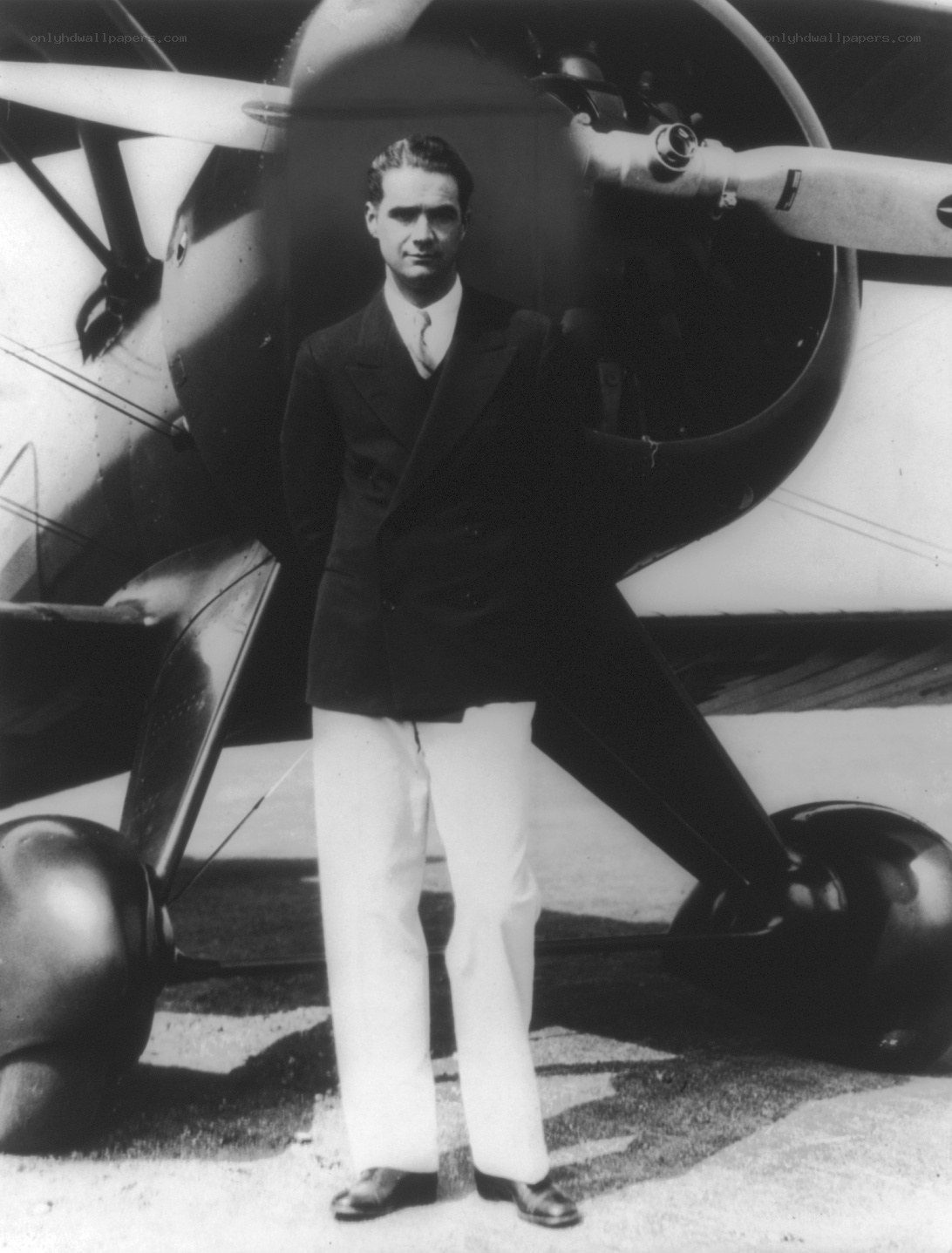 Man in suit standing by airplane