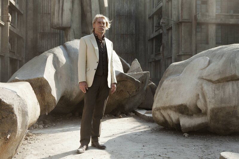 Man in suit stands among ruins