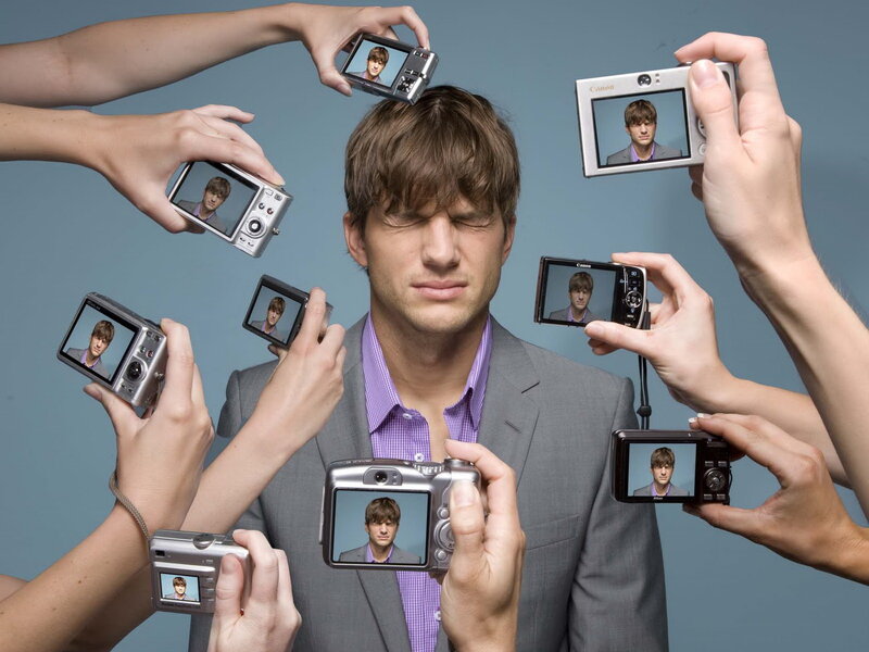 Man in Suit Surrounded by Cameras