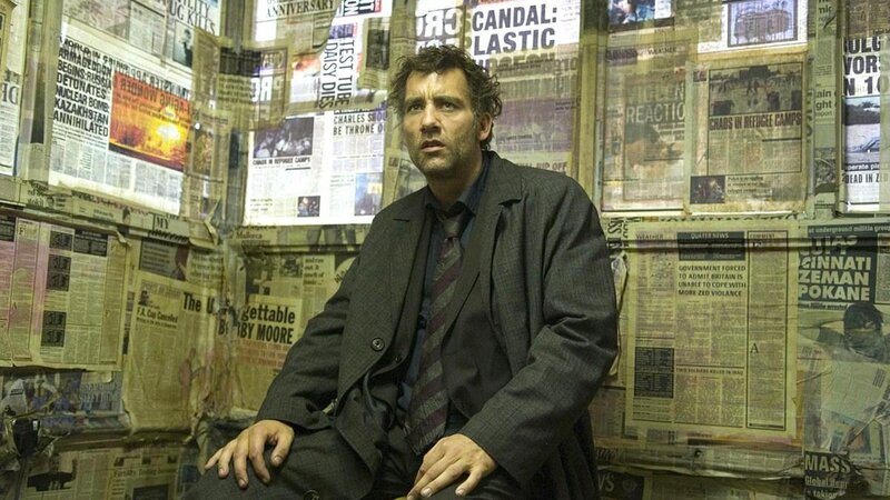 man in suit surrounded by newspapers