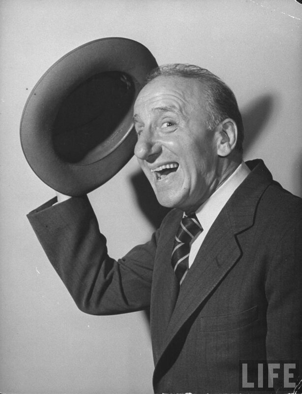 Man in suit tipping hat