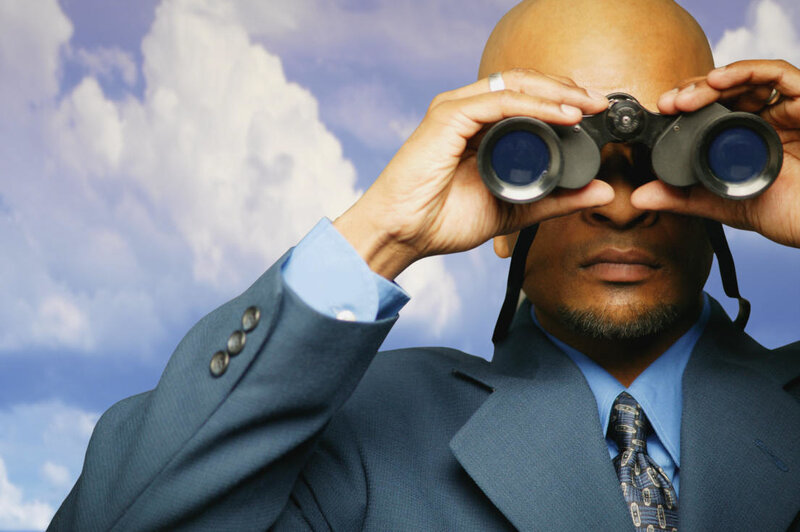 Man in suit using binoculars
