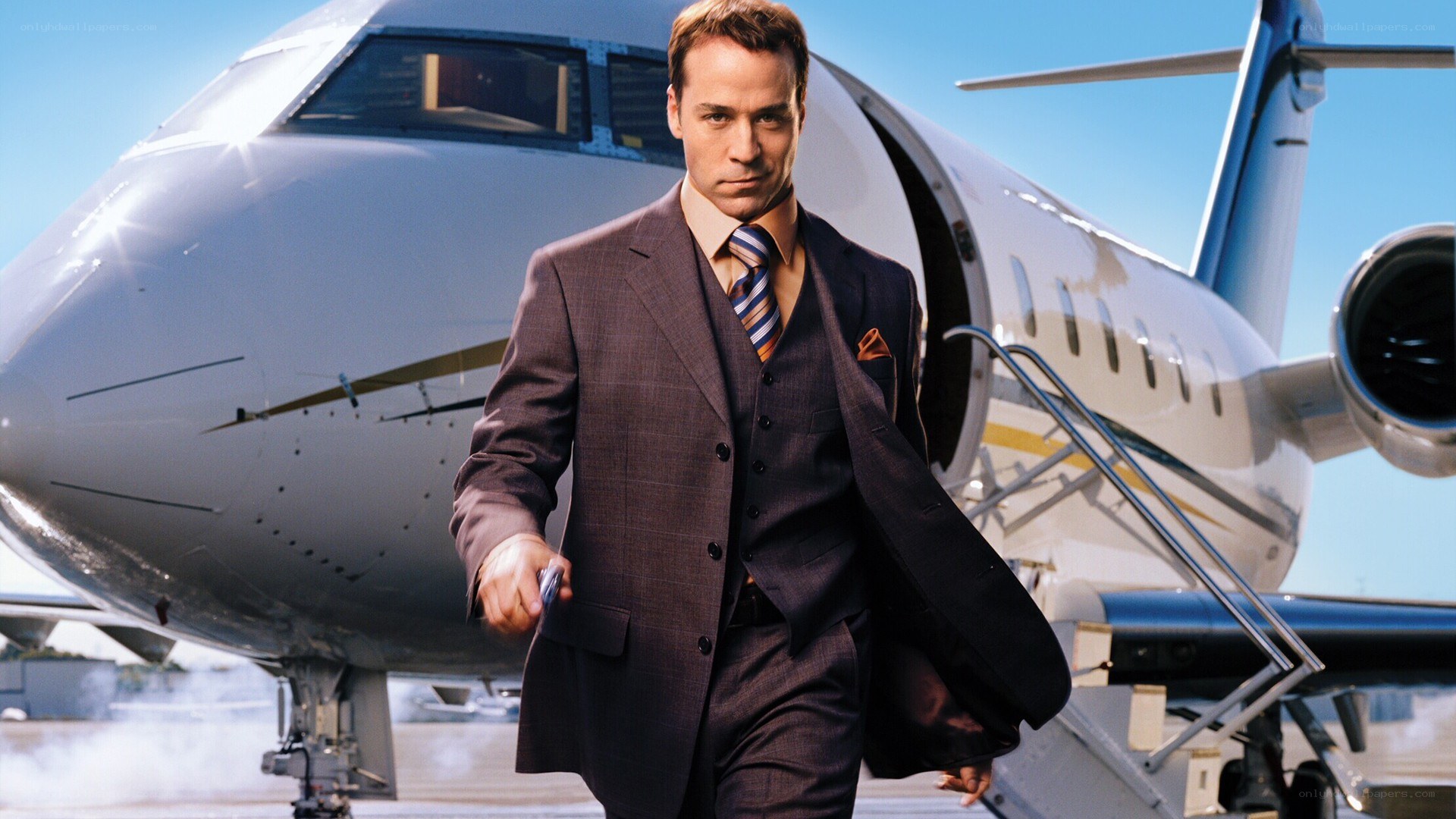 man in suit walking from private jet