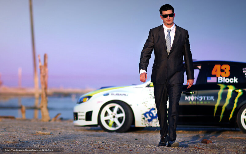 man in suit walking near race car