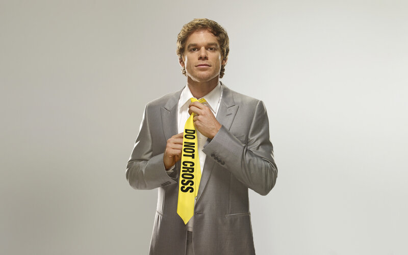 Man in suit with caution tape tie