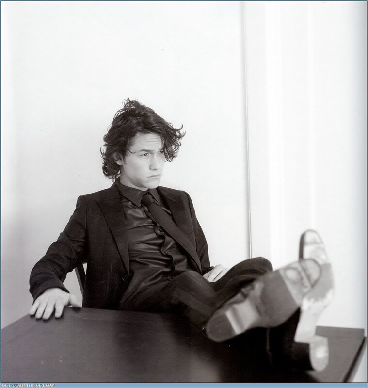 man in suit with feet on table