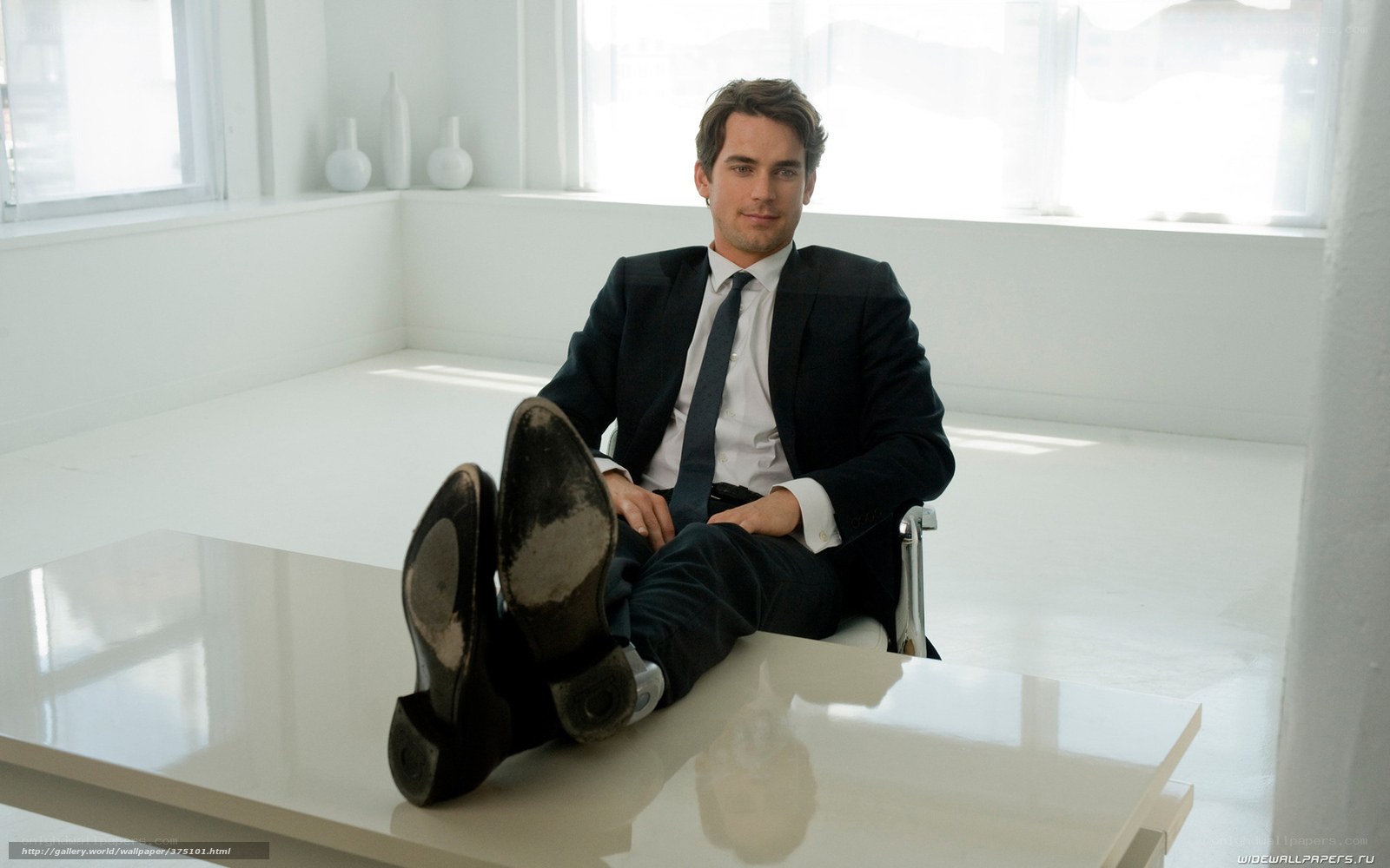 man in suit with feet on table