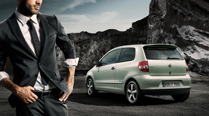Man in suit with green car