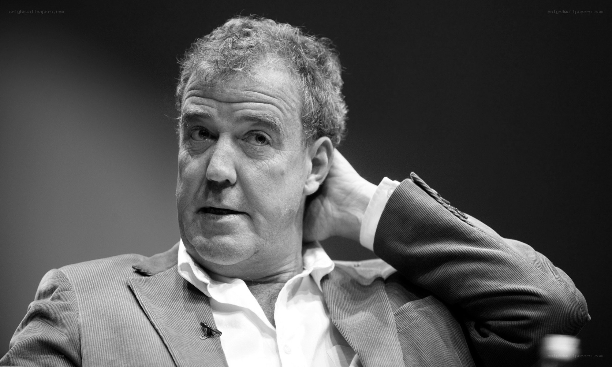 man in suit with hand on neck