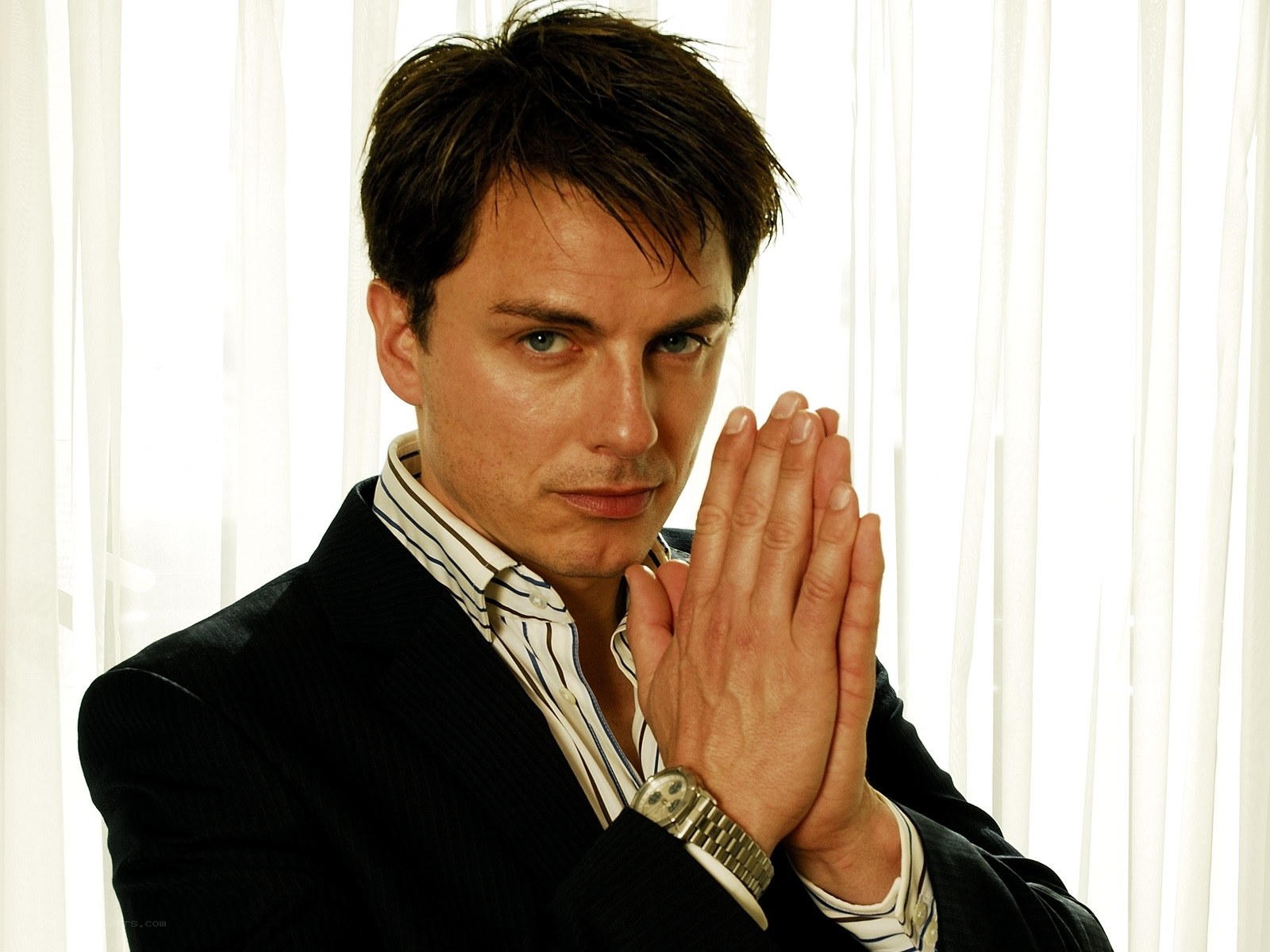 man in suit with hands clasped