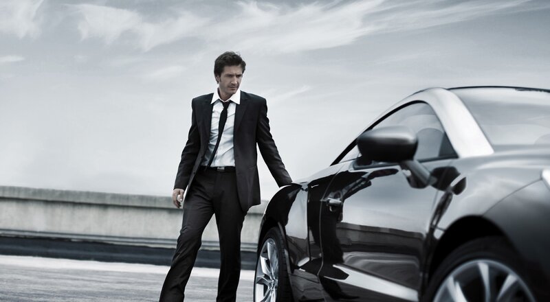 man in suit with luxury car