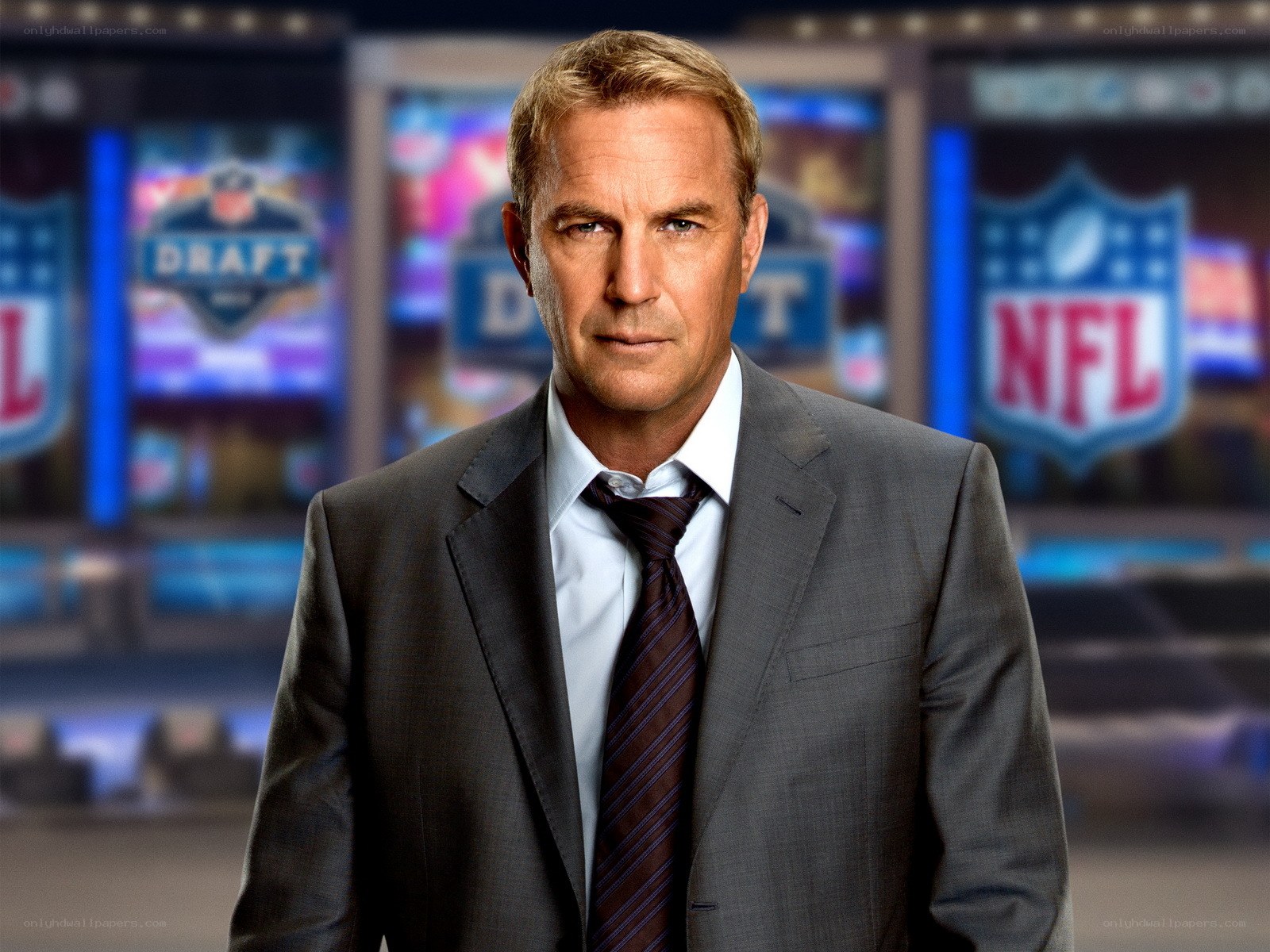 man in suit with NFL background