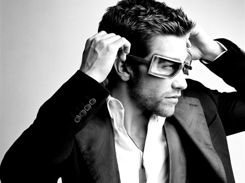 man in sunglasses adjusting hair