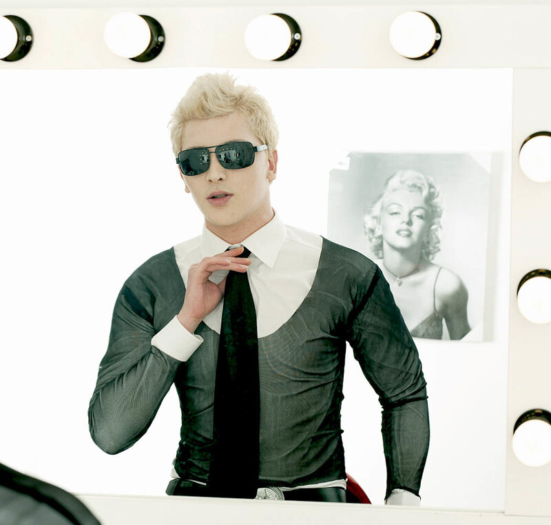 man in sunglasses adjusting tie
