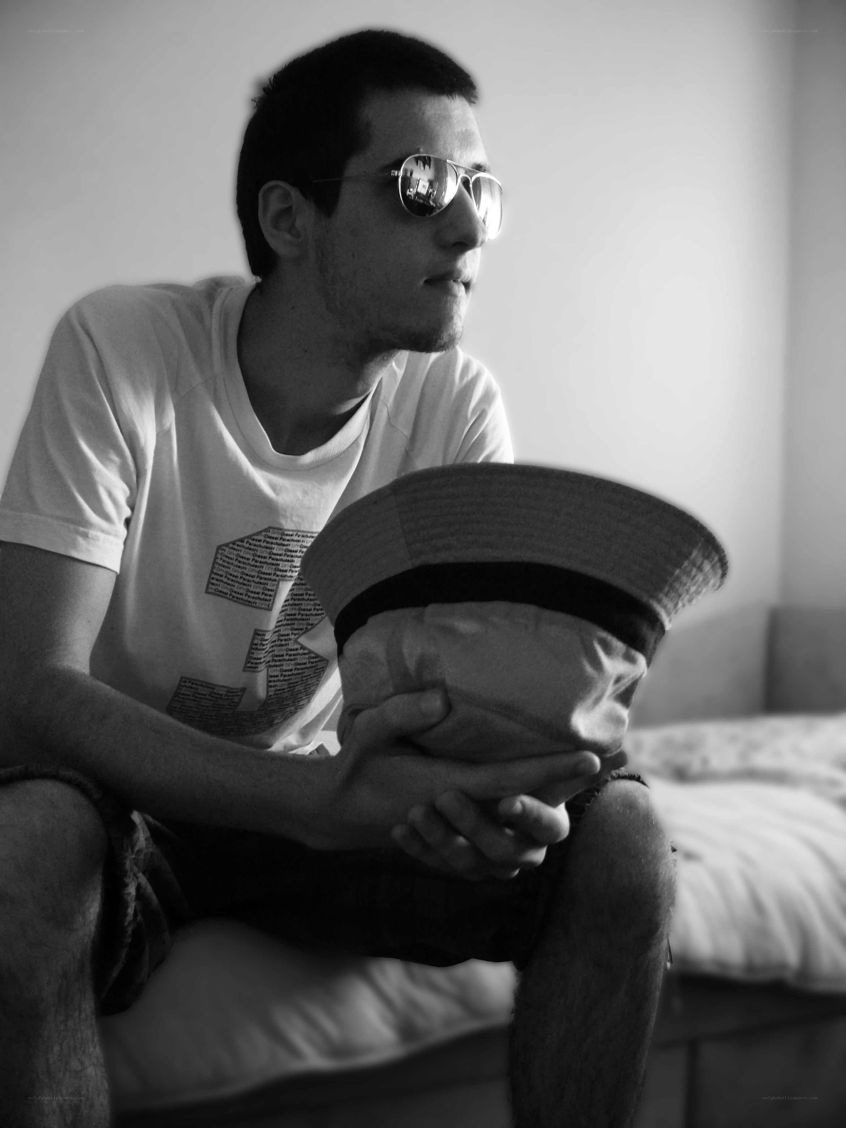 man in sunglasses holding hat