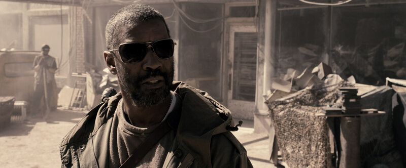man in sunglasses in war zone