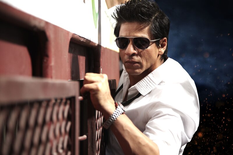 man in sunglasses leaning on fence