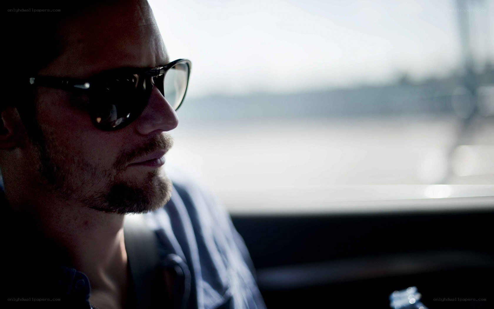 man in sunglasses looking out window