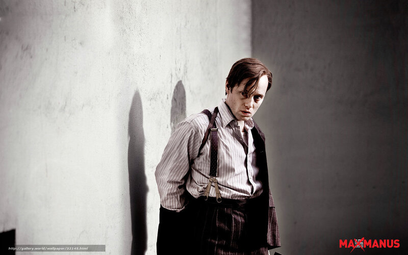 man in suspenders against wall