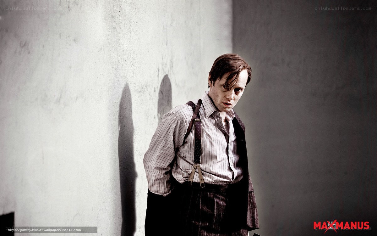man in suspenders against wall