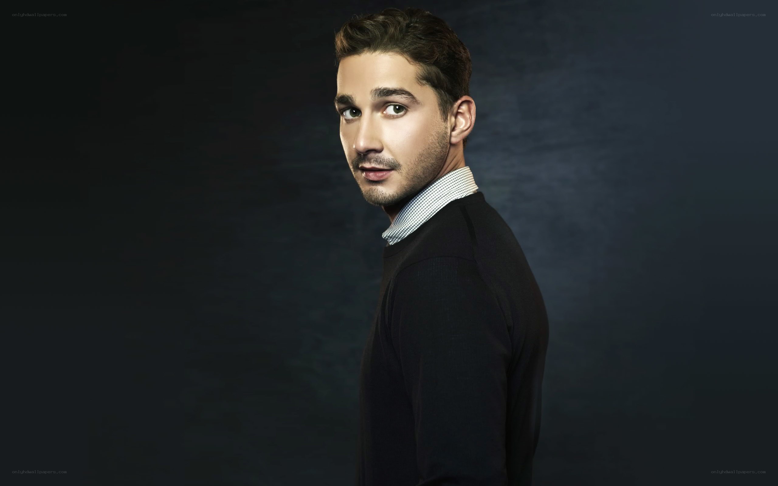 man in sweater looking over shoulder
