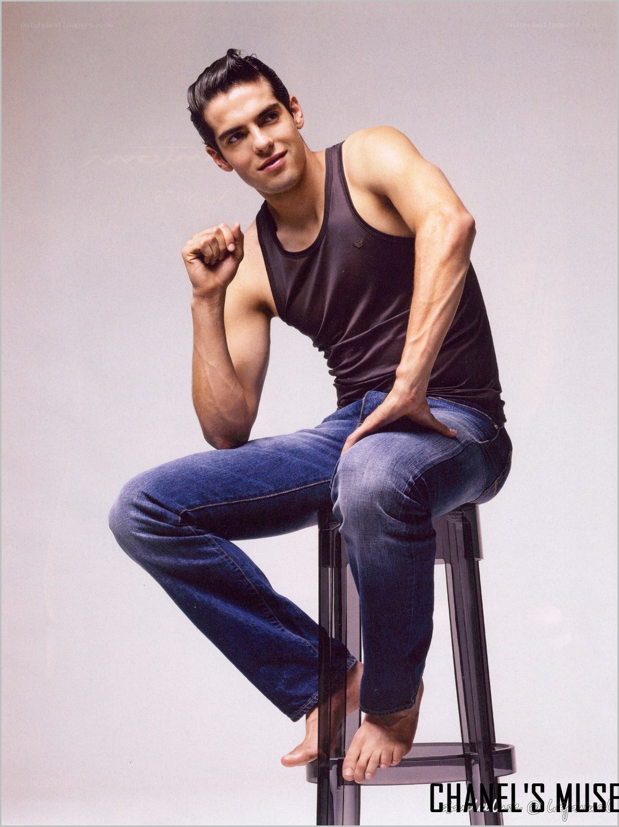 man in tank top sitting on stool