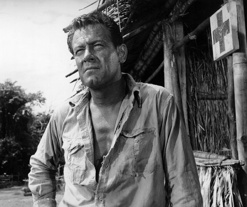 Man in tattered shirt near hut