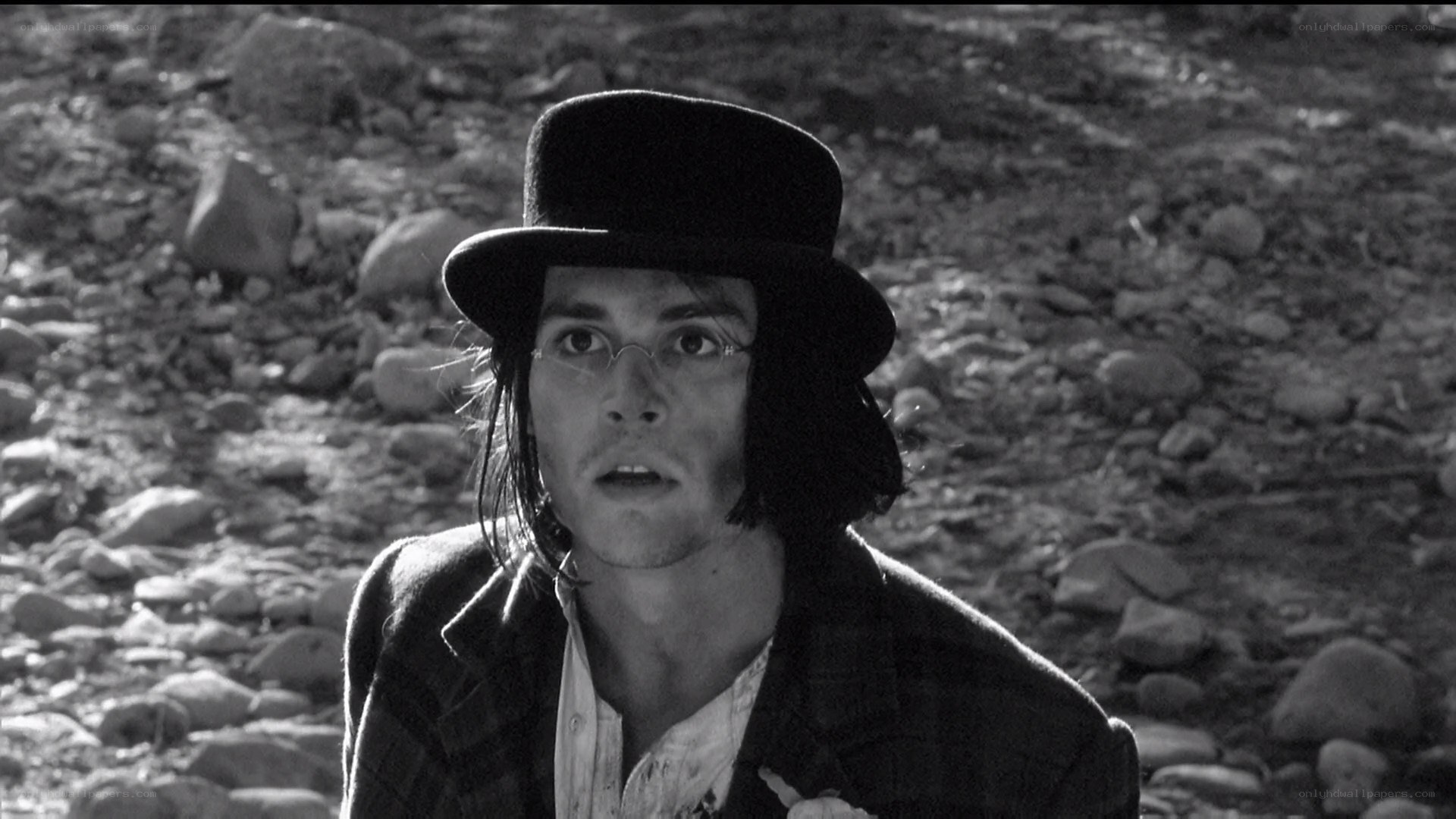 man in top hat on rocky ground