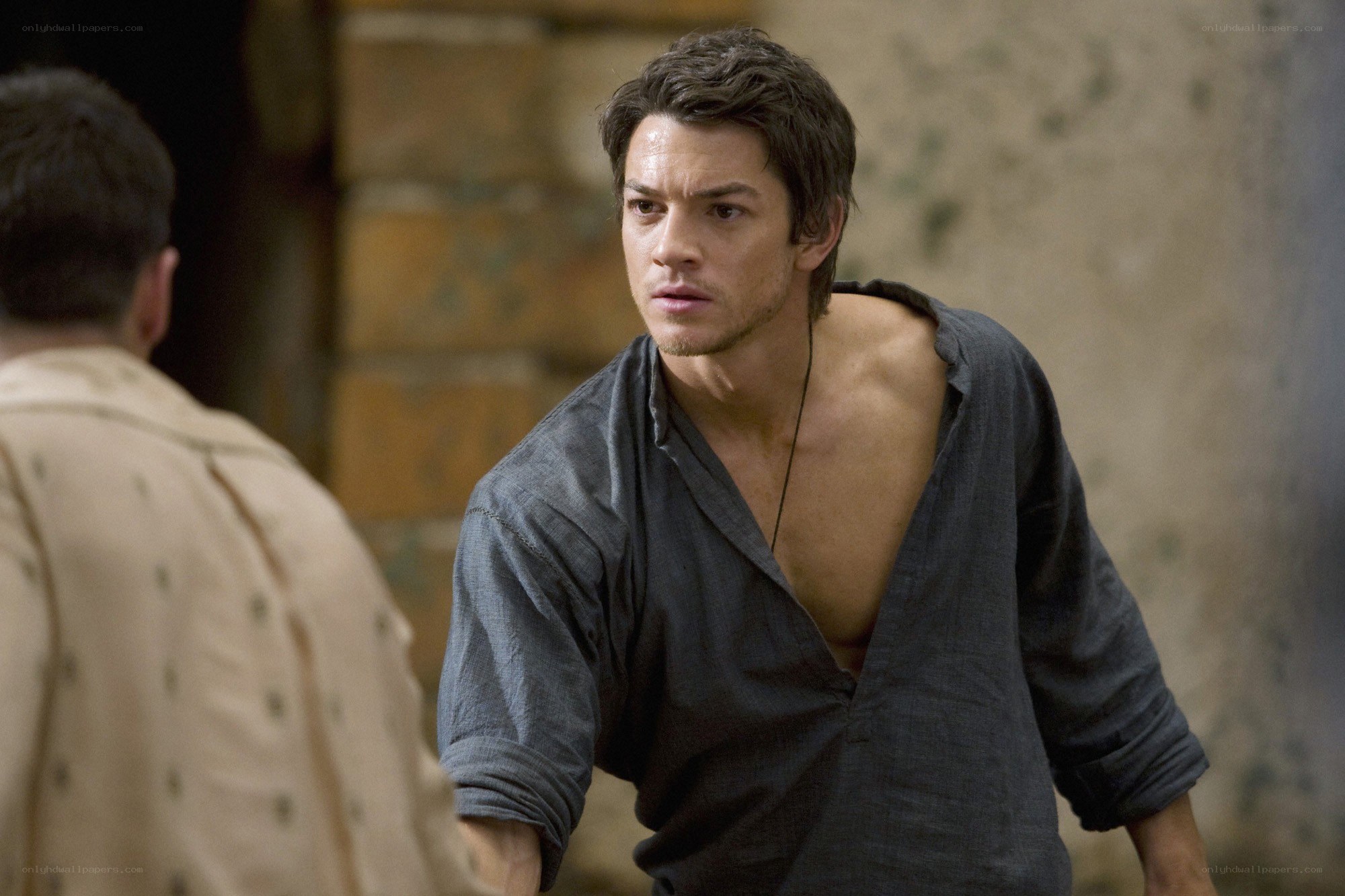 man in torn shirt looking concerned