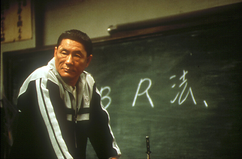 Man in tracksuit by chalkboard