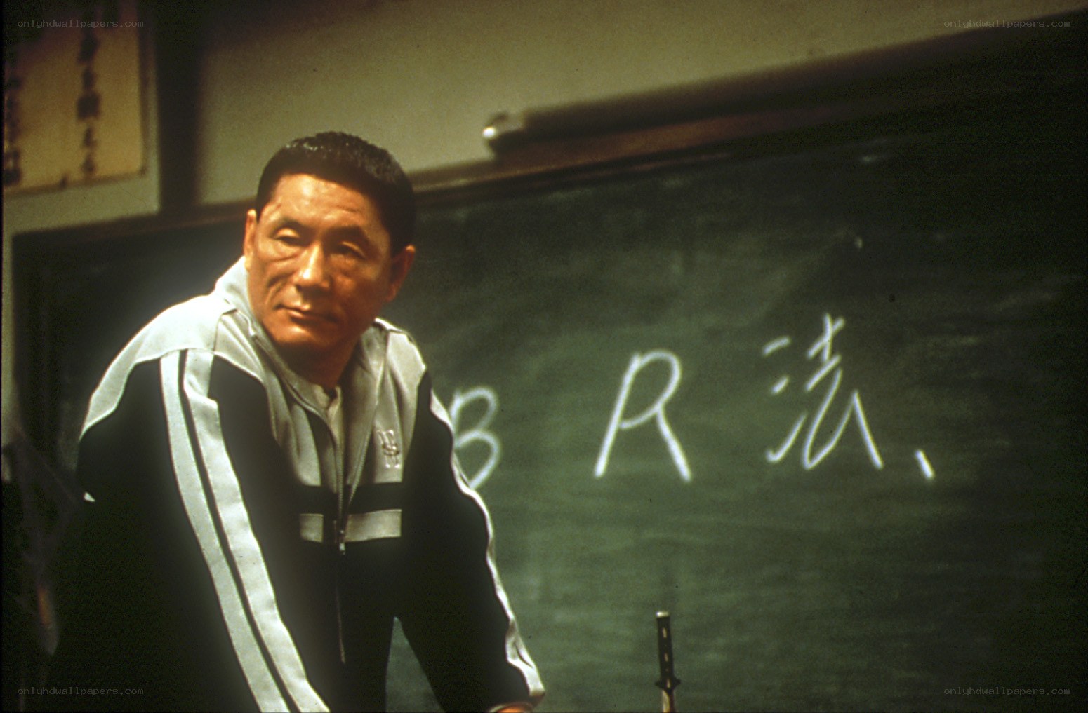 Man in tracksuit by chalkboard