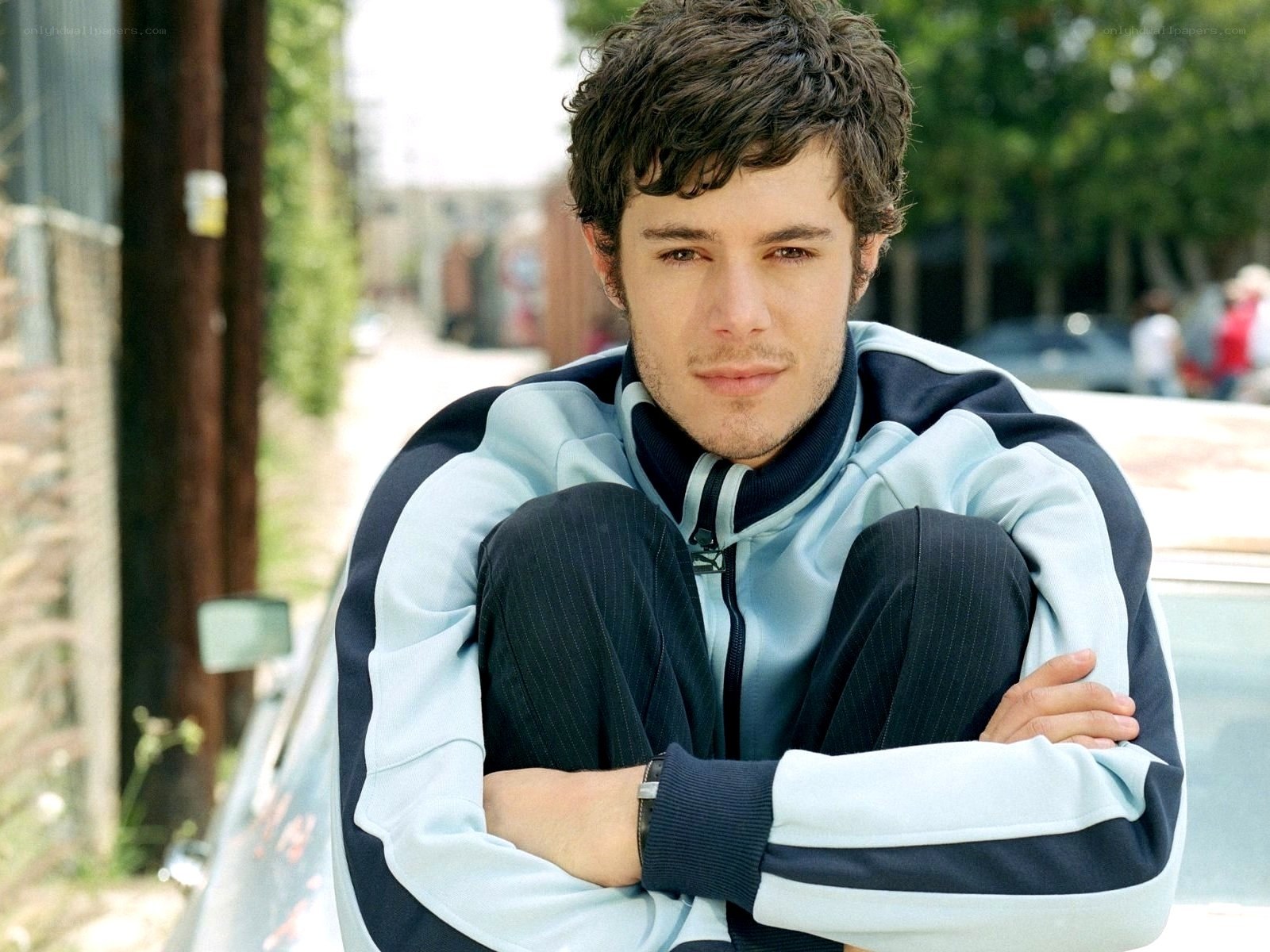 man in tracksuit sitting outside