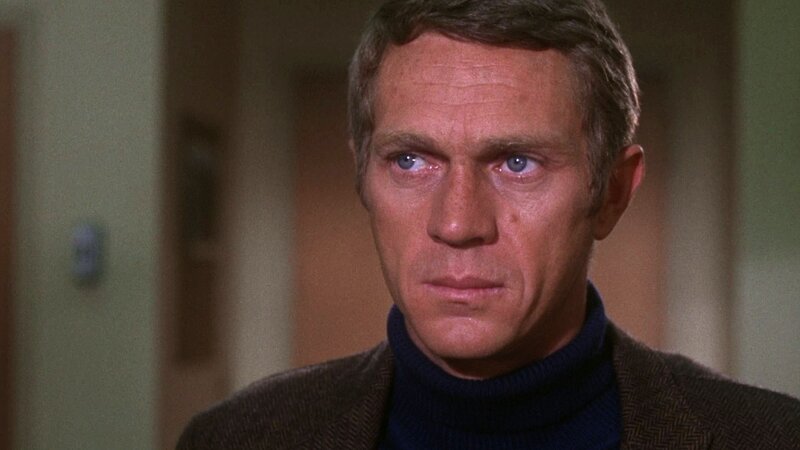 man in turtleneck looking serious