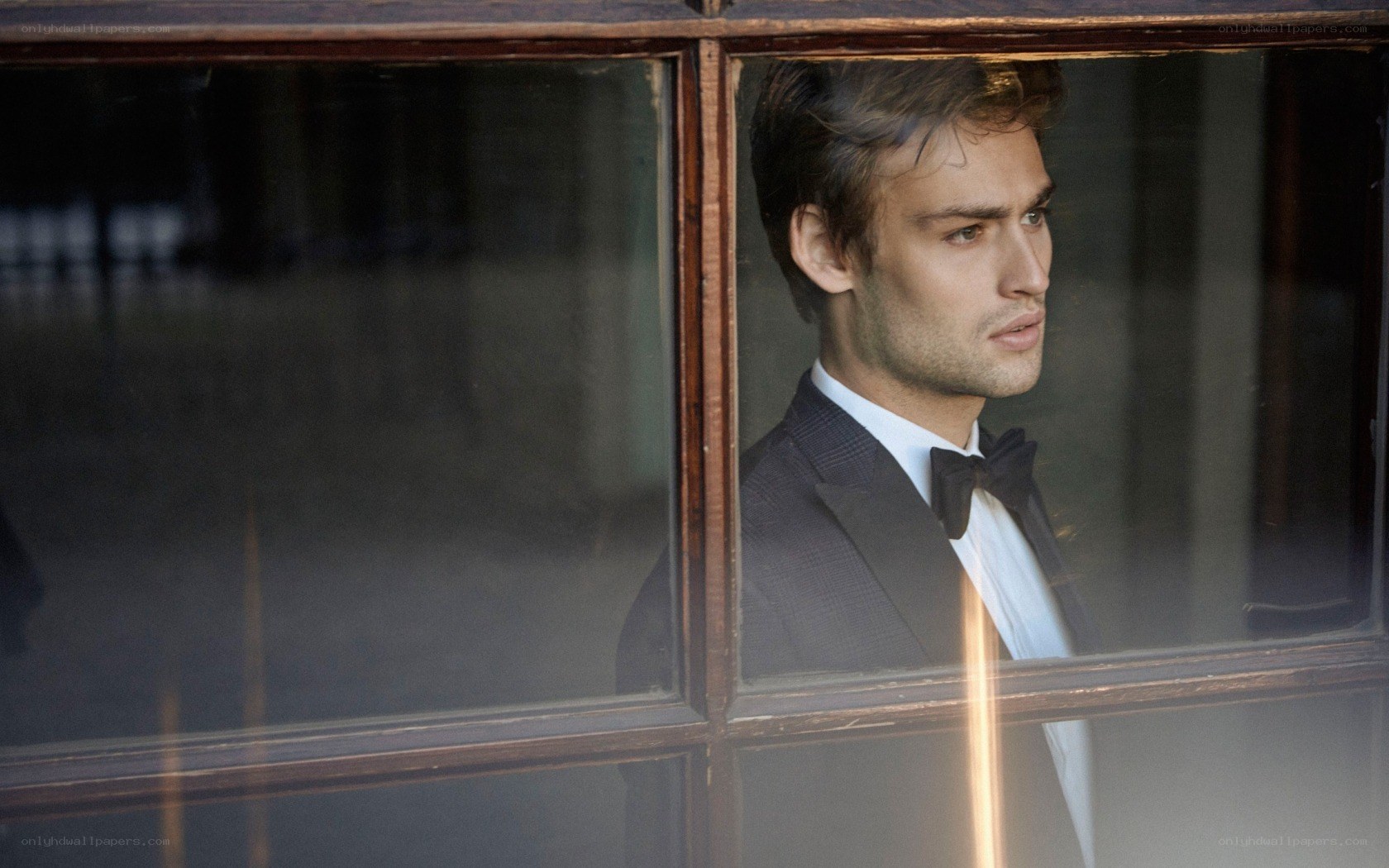 man in tuxedo by window