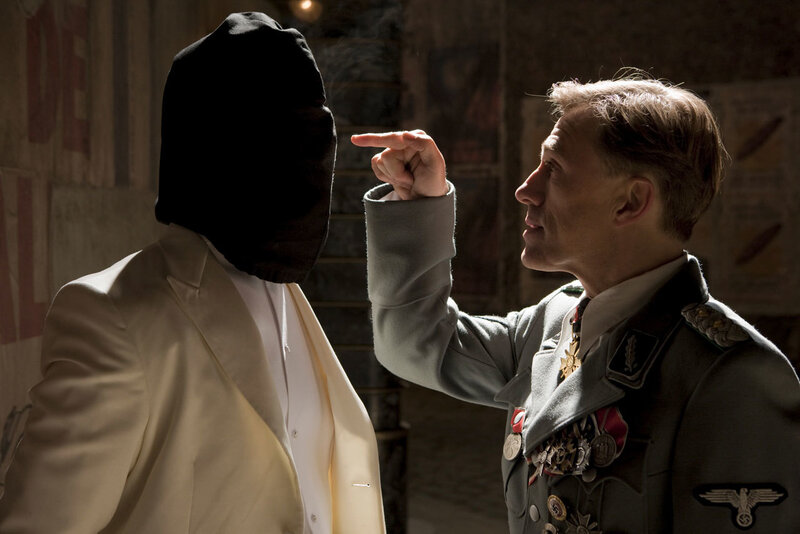 Man in uniform pointing at masked figure