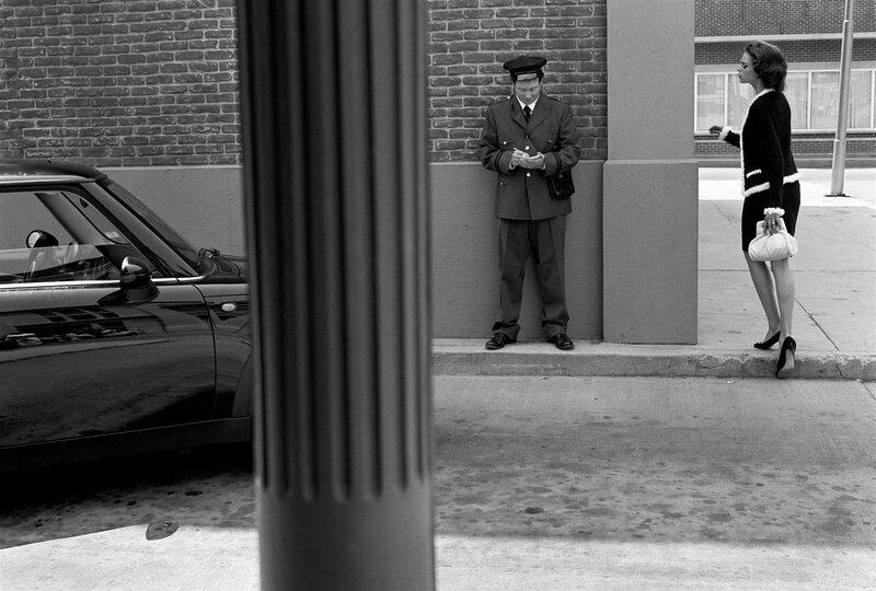 Man in uniform with woman on sidewalk