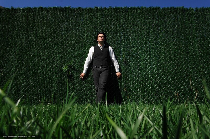 man in vest against green hedge
