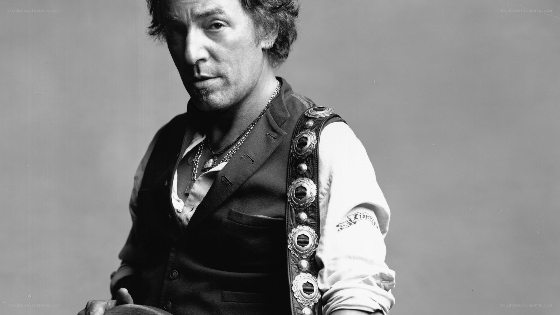man in vest with guitar strap