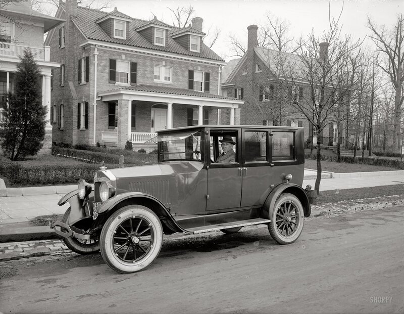 Man in vintage car on street